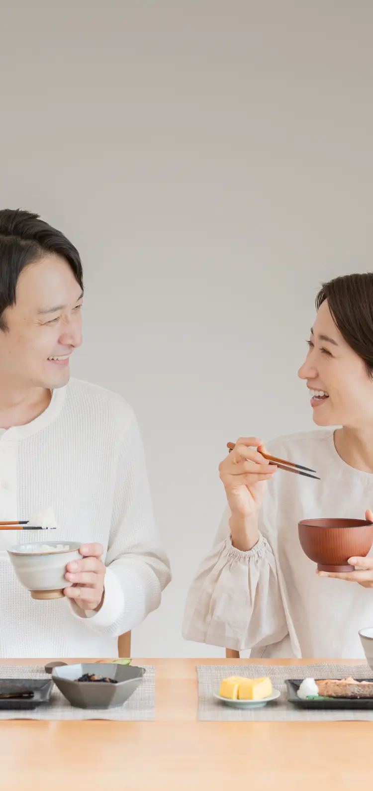 夫婦でお味噌汁をメインで食事している写真